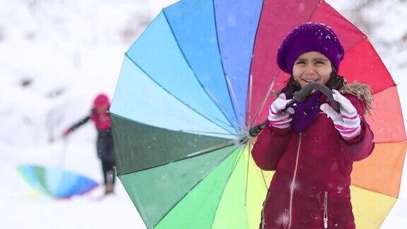 小女孩们在大雪中打着五颜六色的伞