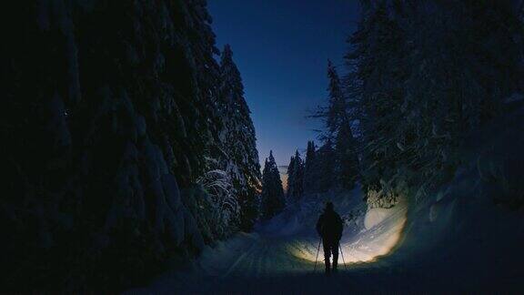 夜深人静的徒步旅行者漫步在冬日的森林里