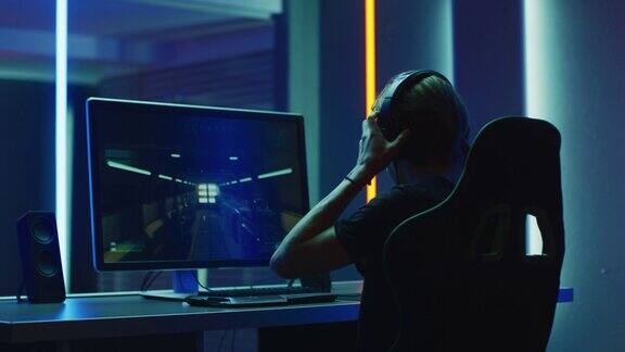 职业玩家在个人电脑上玩第一人称射击游戏通过耳机与队友交谈霓虹色的房间在线电子竞技比赛的行动