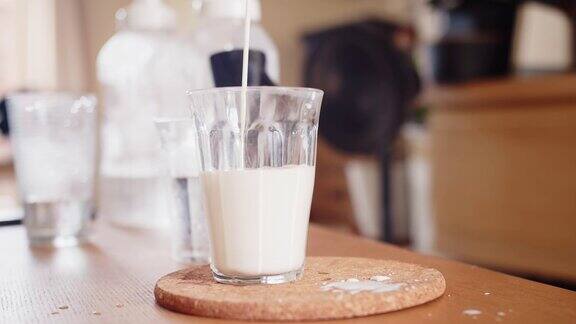 关门时将新鲜牛奶倒进木桌上的空杯子里早餐吃健康的食物