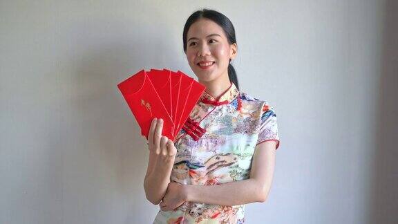 美丽的亚洲妇女穿着带有红包的中国传统服装