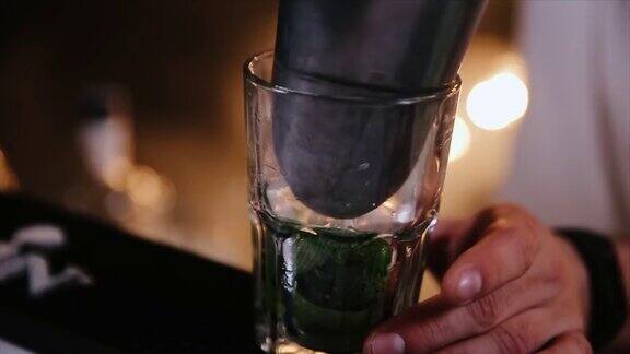 一个调酒师在准备酒精鸡尾酒莫吉托的时候把专业的水晶冰块放在玻璃杯里近距离