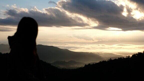 模糊的剪影一个女旅行者在雾天看美丽的山景