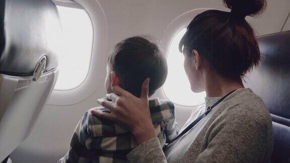 母亲和儿子在飞机上看照片
