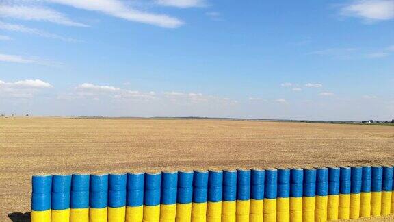 蓝色和黄色的旗帜由干草捆在麦田与蓝色的天空