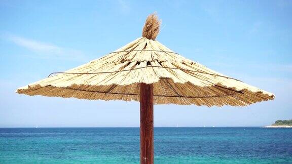 茅草沙滩伞的背景是蔚蓝的大海