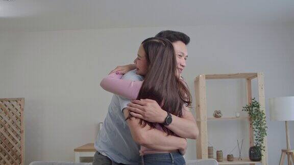 这是一对幸福的年轻亚洲夫妇在房间里拥抱的慢镜头年轻人拥抱