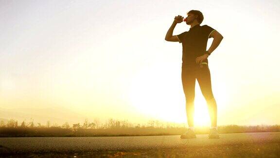 马拉松运动员在广角山景上饮水