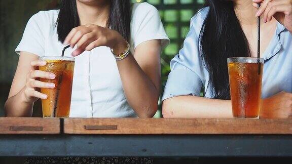 在café网站妇女们用塑料杯喝冰茶的特写镜头