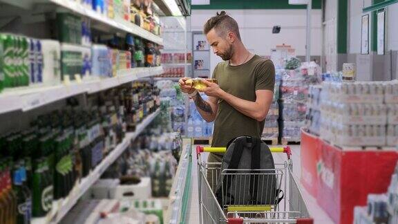 一个年轻人正在超市里买啤酒