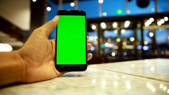 手持绿色显示屏的手机