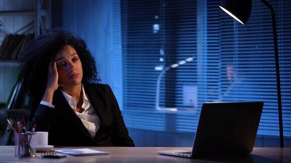 以开灯和关灯为背景的疲惫的非裔美国女性肖像女商人在工作场所坐在桌子在办公室内部慢动作准备59.94帧