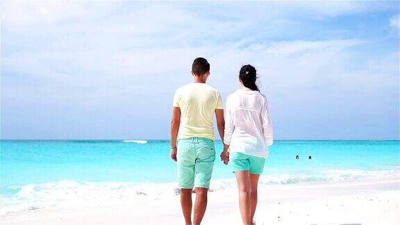 一对年轻夫妇在白色的海滩上度过暑假幸福的情侣享受他们的蜜月慢动作视频