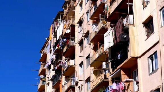 在这座城市贫困地区的高层老房子阳台之间的晾衣绳上晾衣服