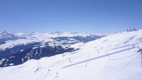 空中全景镜头的滑雪斜坡在冬季山区度假村阿尔卑斯山积雪覆盖的山脊瑞士Laax