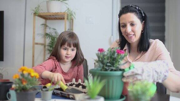 可爱的小女孩帮助她的妈妈照顾植物