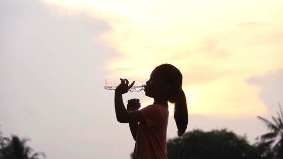 亚洲小女孩在公园里快乐地喝水慢镜头