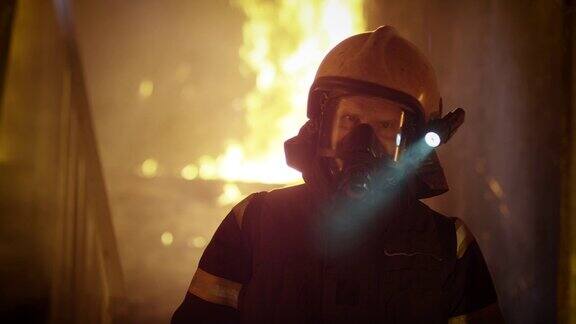 一名勇敢的消防员站在燃烧的大楼里熊熊大火在背景中燃烧