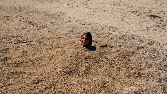 沙滩上躺在沙子里的有趣少女