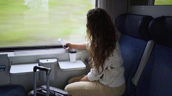 在火车上的女人手机靠近窗户