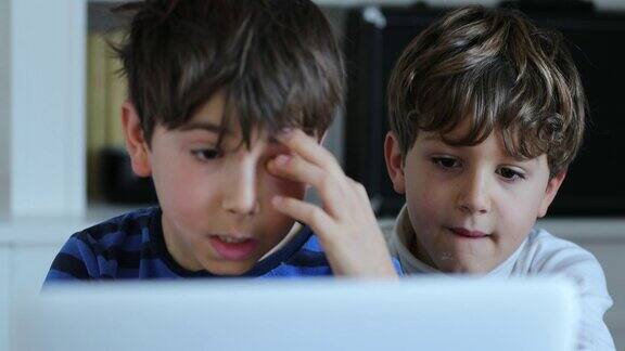 孩子在揉眼睛的同时盯着电脑屏幕孩子们在电脑前上网看网络媒体内容