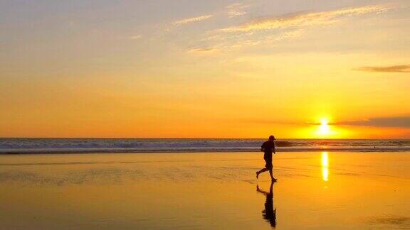 慢镜头:金色的夕阳下一个面目全非的男人在光滑的沙滩上奔跑