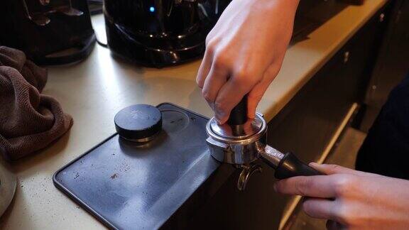 咖啡师女孩正在捣碎咖啡在酒吧里做浓咖啡