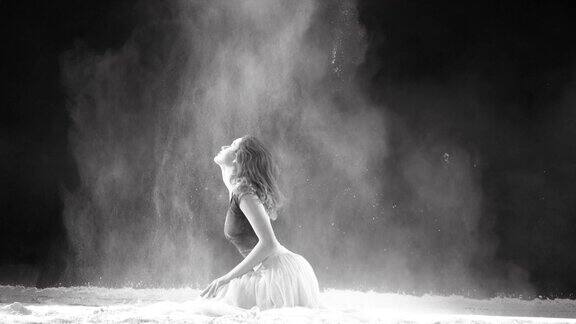 美丽的芭蕾舞演员在粉雪中跳舞