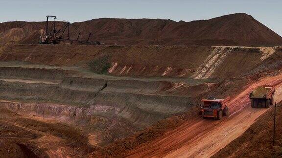自卸卡车从采石场运出矿石矿井全景图新月形沙丘砂矿产资源的开发