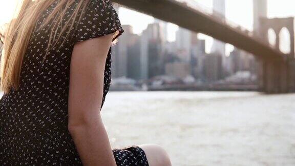 体贴的女孩戴着太阳镜和惊人的头发在风中吹享受纽约日落风景慢动作