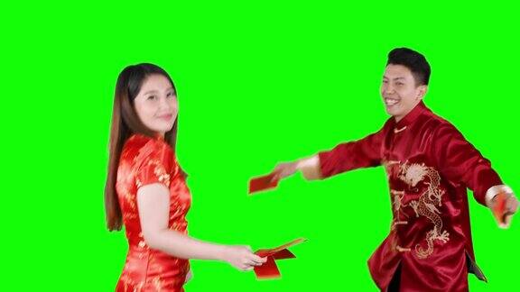 幸福的亚洲夫妇拿着红包跳舞