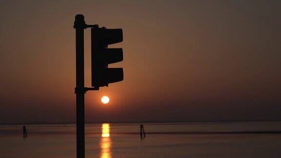 日落时湖面上交通灯的剪影