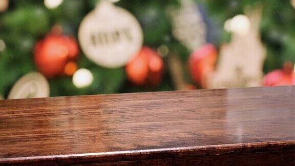 空对角线木制桌面模糊的绿色圣诞树装饰红色的小装饰品和串光背景与雪假日背景的广告产品展示
