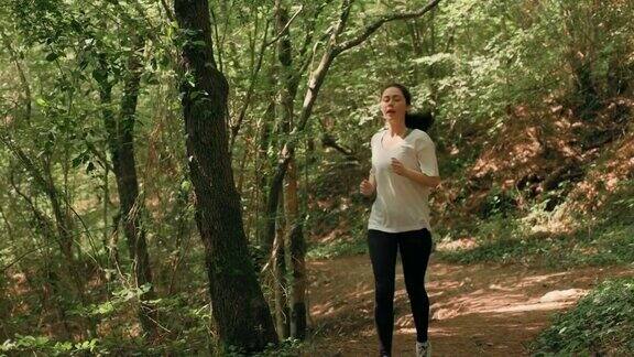 越野跑步一个穿着运动服的心不在焉的女人在森林里慢跑缓慢的运动有氧运动训练和健康生活方式