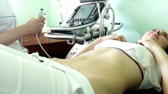 男医生用超声波扫描仪检查这位女士的腹部器官