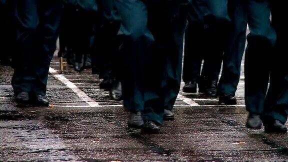 军队在阅兵式的操场上行进雨中的脚在画面里