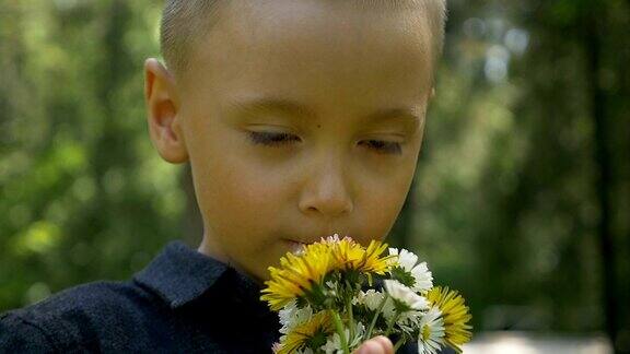 可爱的孩子闻着春天的花朵在大自然中感受快乐的特写