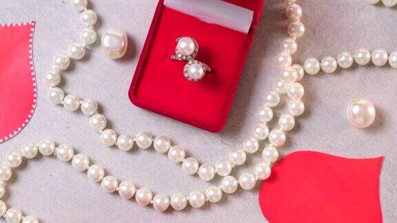 红盒子里的金戒指和珍珠情人节的浪漫背景有宝石、礼物、订婚戒指等求婚、婚礼或节日礼物贺卡旋转