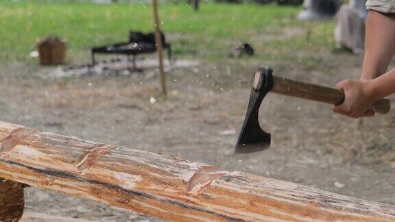 慢镜头:一名伐木工人在历史节日上用斧头砍着大木头