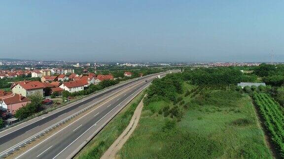 夏天一个城镇旁边的一条高速公路的无人机视图