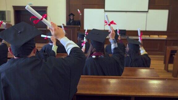 毕业典礼上毕业生们挥舞着毕业证欢呼雀跃