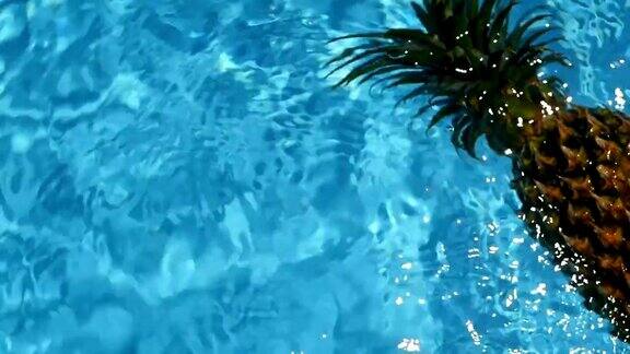 菠萝漂浮在游泳池的蓝色的水健康生有机食品多汁的水果素食纯素营养维生素饮食暑假假期概念奇异的热带背景