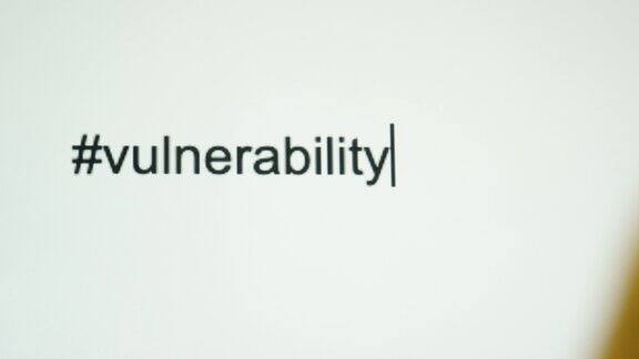 一个人在电脑屏幕上键入“#脆弱性”