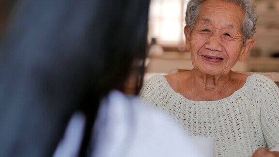 老年妇女与年轻的黑人女护士交谈帮助病人在家进行医疗咨询老祖母倾听照顾者给予的支持老年人的医疗保健医疗照顾护理退休志愿者养老院在家里照顾者