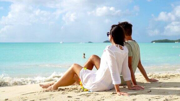 一对年轻夫妇在白色的海滩上度过暑假