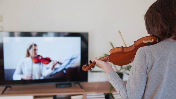 男孩在网上和老师学习小提琴