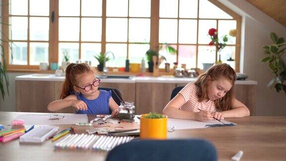 两个女孩在玩的时候在家里用水彩画