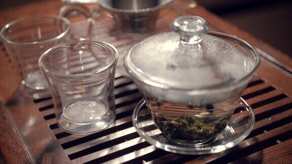 在木制茶几上用玻璃杯盖丸冲泡乌龙茶