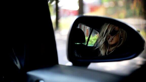 年轻女子看着汽车后视镜