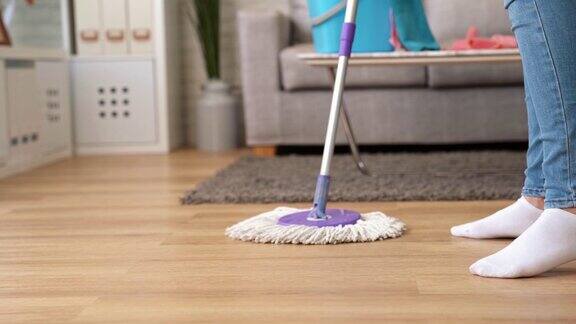 妇女在家里用拖把擦地板